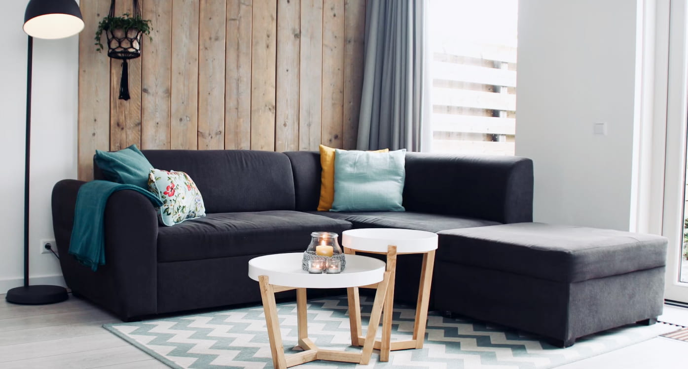 Gemütliches, möbliertes Wohnzimmer mit Sofa und Beistelltischen, wie bei Wohnen auf Zeit üblich